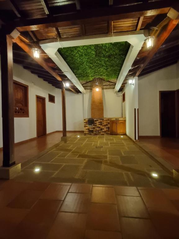 Hermosa y Acogedora Casa de Descanso & Mirador في باريكارا: غرفة كبيرة مع سقف أخضر في مبنى