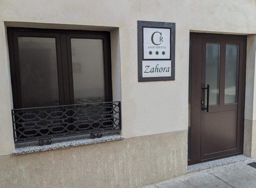 - une porte et un balcon sur le côté du bâtiment dans l'établissement Apartamento Rural Zahora, à Hervás