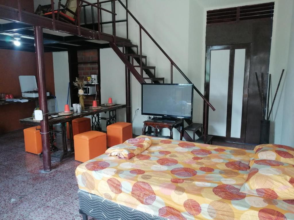 Pokój z łóżkiem, telewizorem i schodami w obiekcie "La Casa del Abuelo" w mieście Santa Ana