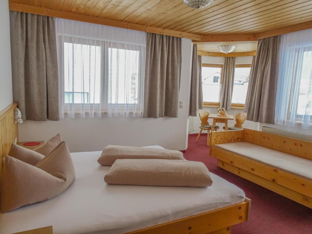 a bedroom with three beds in a room with windows at Garni Apart Wallamotta Silvretta Card Premium Betrieb in Galtür