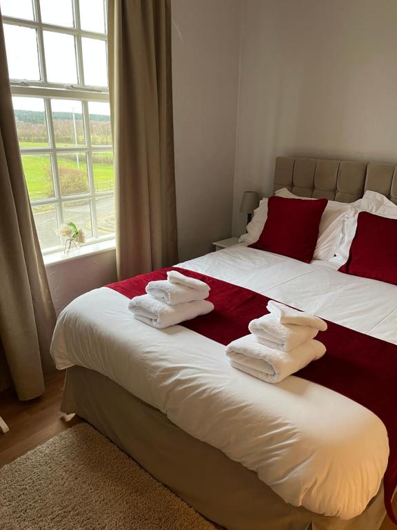 The Old Postie Bed & Breakfast في Annesley: غرفة نوم بسرير كبير عليها مناشف