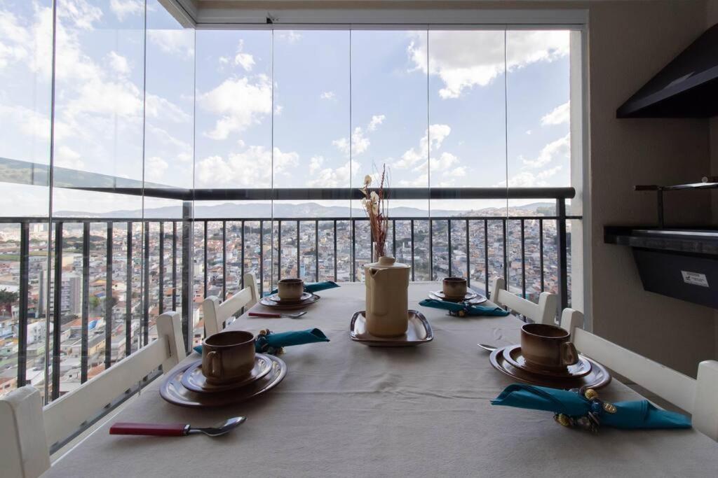 a table in a room with a view of a city at Sunshine Studio - GRU in Guarulhos