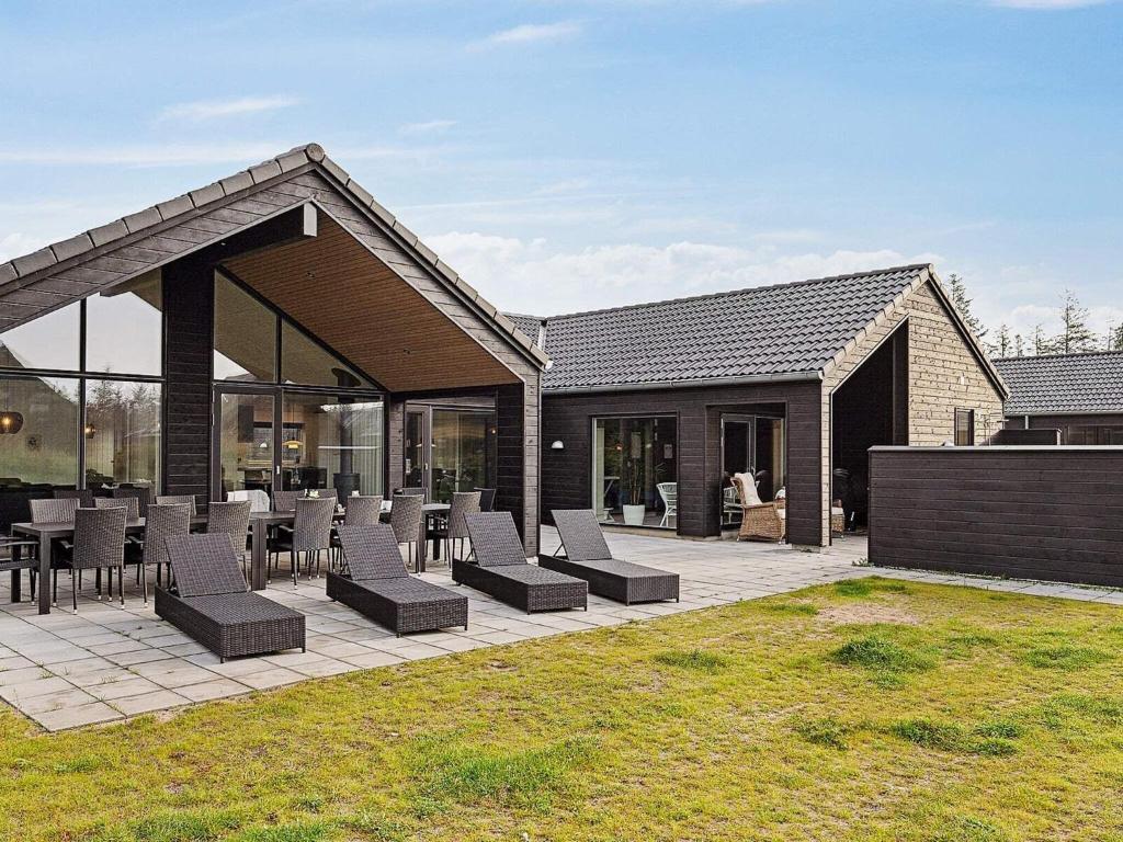 a patio with chairs and tables in front of a house at Luxury Retreat with Pool - By Traum Ferienwohnungen in Kongsmark