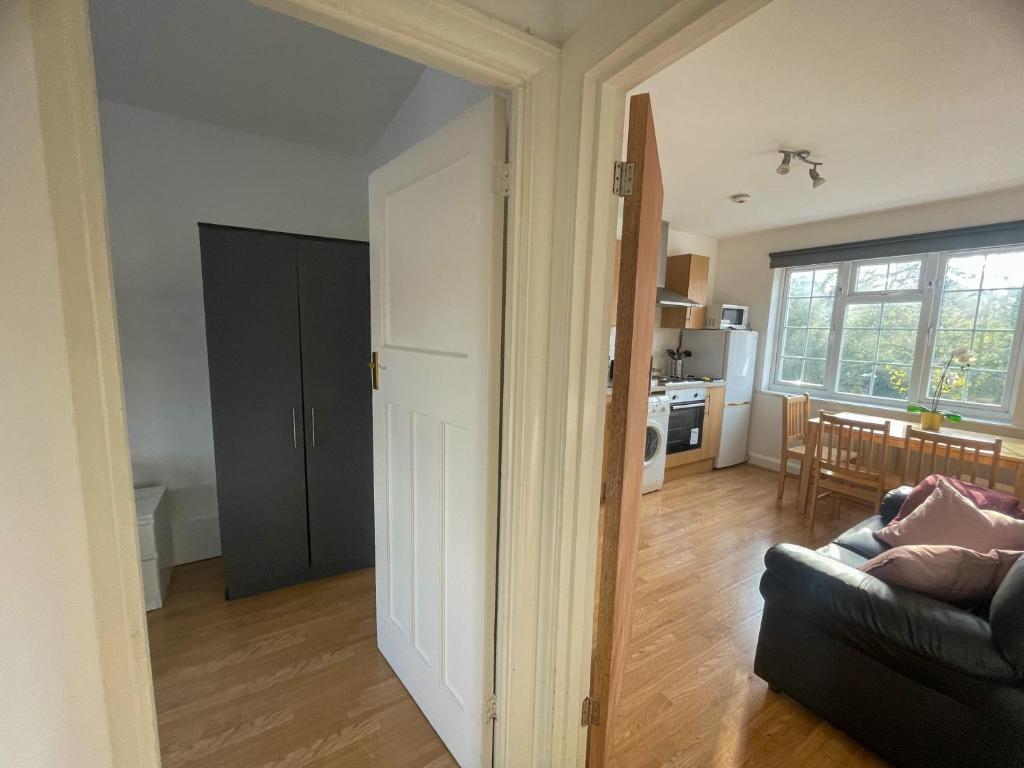 a living room with a couch and a kitchen at Pinner apartments in Pinner