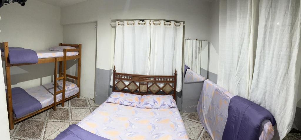 um quarto com 2 beliches e uma cama em kitnet em cabo frio 01 em Cabo Frio