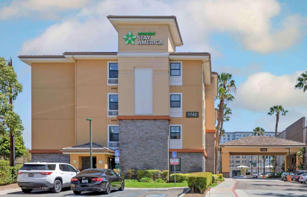 een hotelgebouw met auto's die ervoor geparkeerd staan bij Extended Stay America Suites - Orange County - Anaheim Convention Center in Anaheim