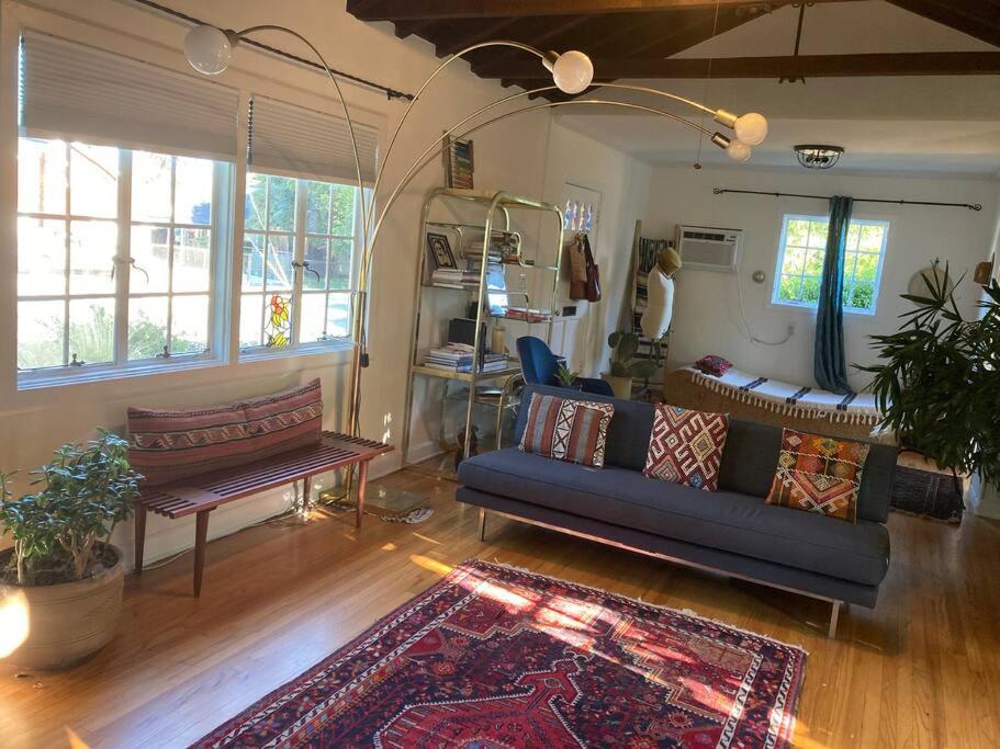 a living room with a blue couch and a rug at Gorgeous boho bungalow in the heart of Pasadena in Pasadena