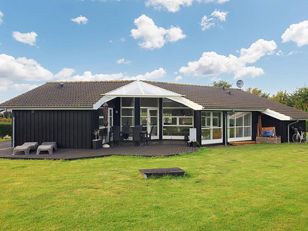 een huis met een terras en een grote tuin bij 10 person holiday home in Rudk bing in Spodsbjerg
