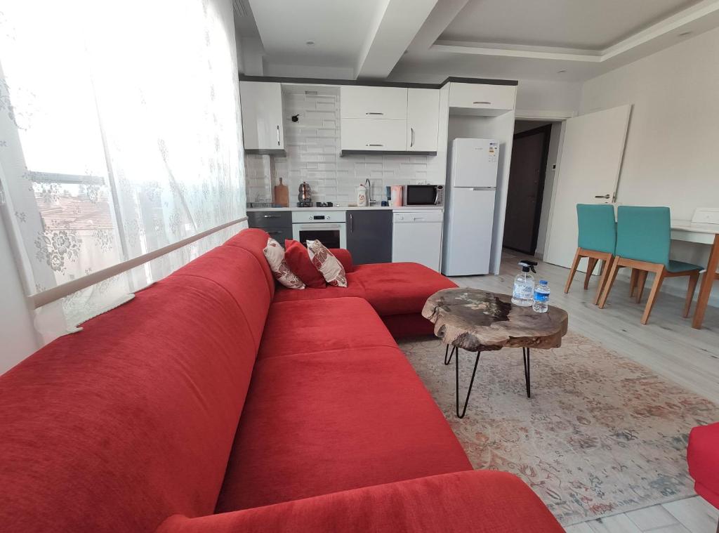 a living room with a red couch and a table at Denizolgun Homes Gazibulvarı in Dalaman