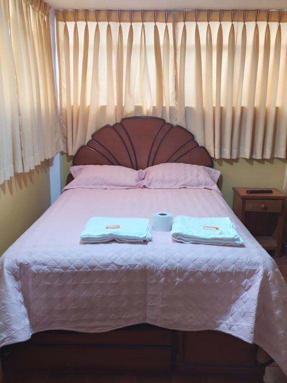 a bed with two towels and two cups on it at Dream House B&B in Huaraz