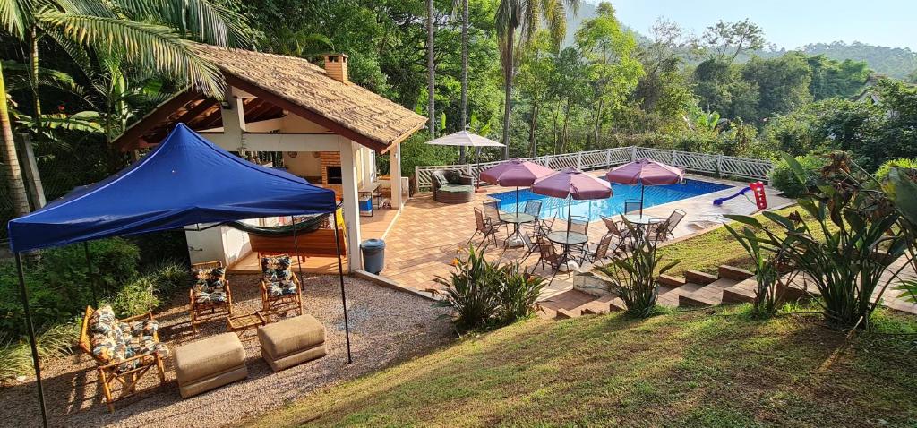 une maison dotée d'une piscine avec des parasols violets dans l'établissement Casarão perto SP e Rodeio Cajamar - Piscina, Hidro e Lareira com Brinquedos em condomínio de Luxo, à Cajamar