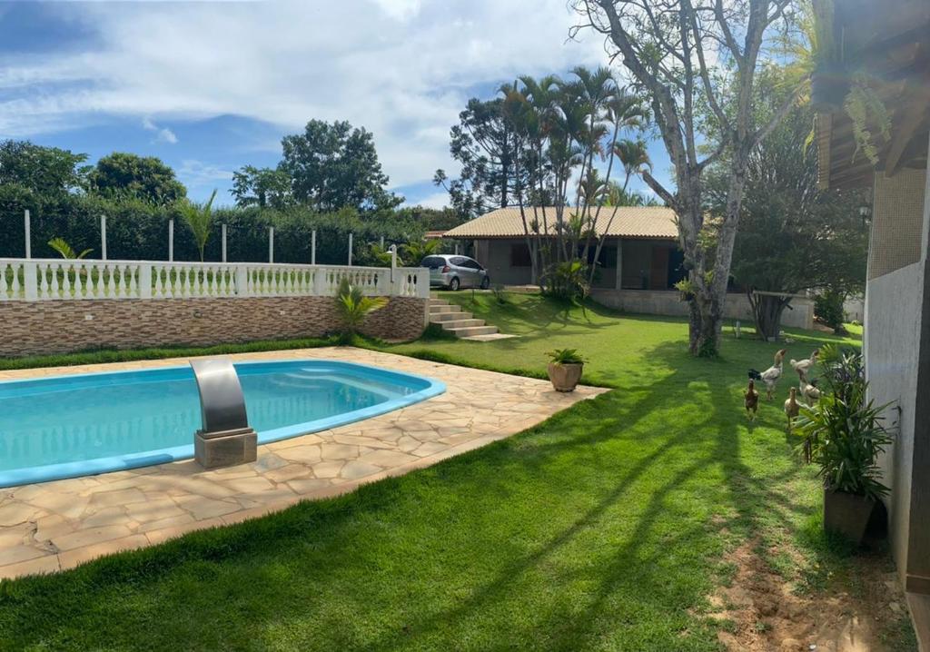 een tuin met een zwembad en een huis bij Chacara recanto da paz in Mairinque