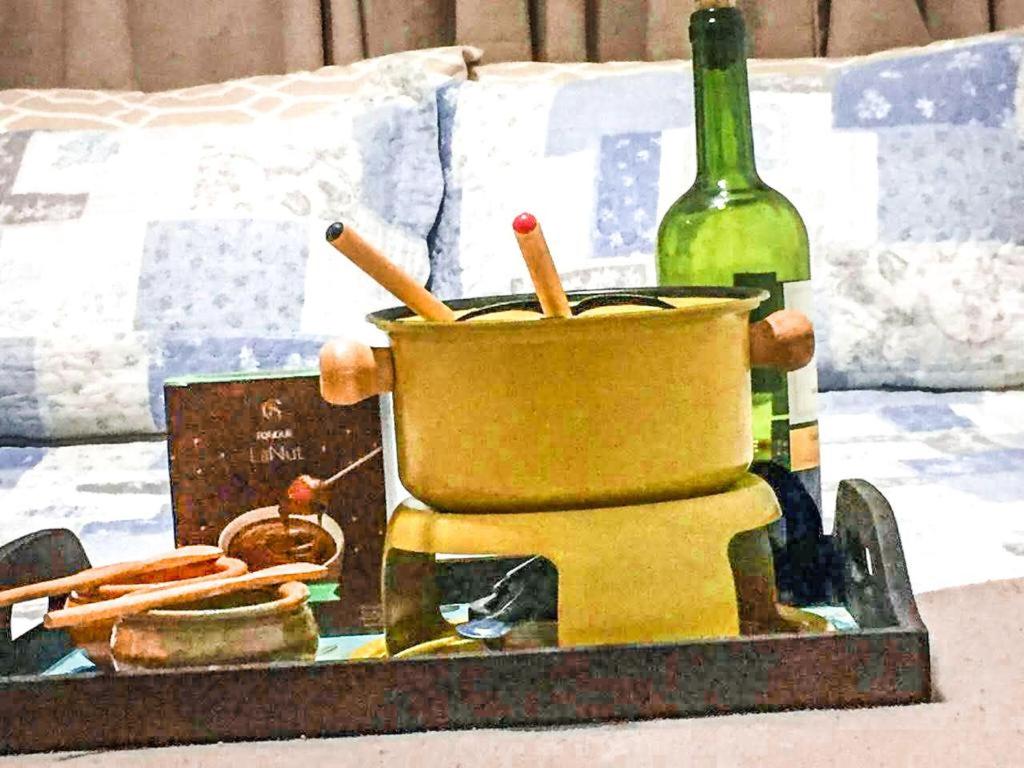 a bottle of wine and a mortar and pestle with a wine glass at Suítes Apoena in Arraial do Cabo