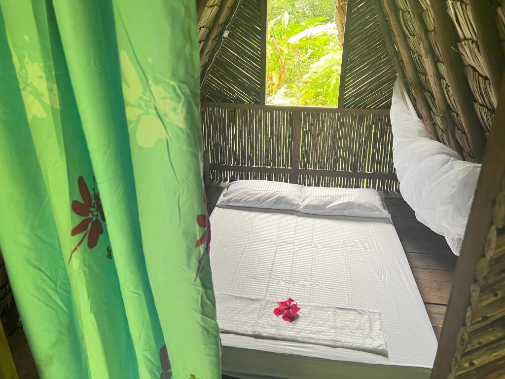 a small bed in a room with a window at La Aldea del Primitivo in Nuquí