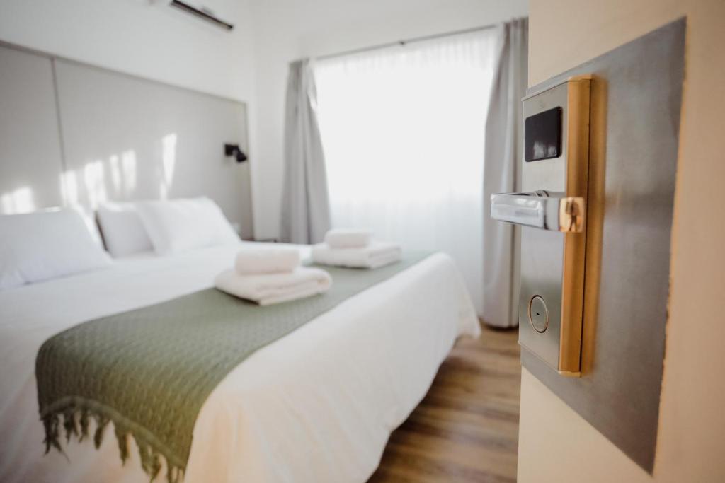 a bedroom with a bed with two towels on it at Hotel Barda Sur in General Roca