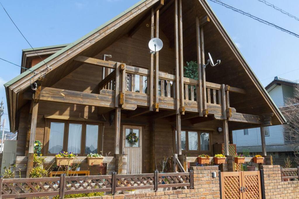 une grande maison en bois avec une grande véranda dans l'établissement Log house Tomi-chan's house / Private building, à Echizen