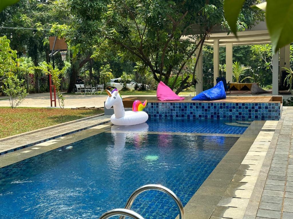 a pool with some inflatable animals in the water at Arunni garden in Bogor