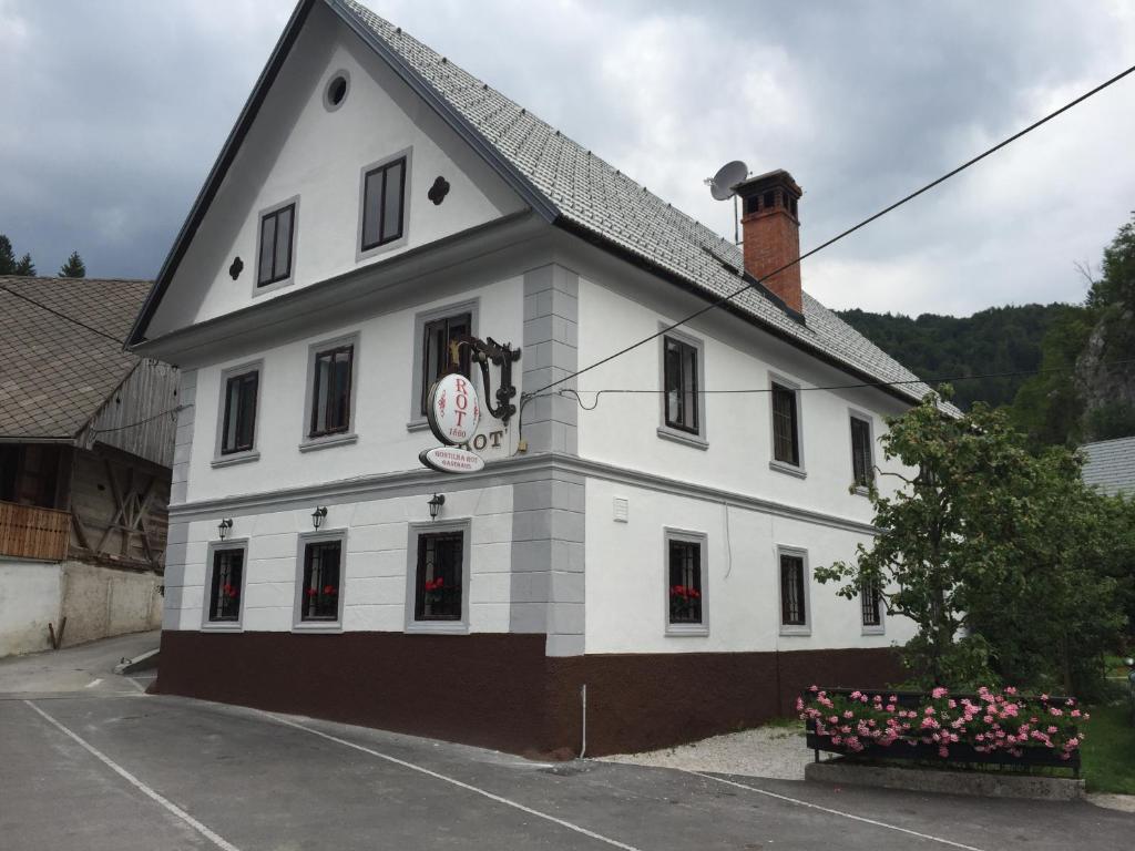 Biały budynek z zegarem w obiekcie B&B Rot w mieście Bohinjska Bela