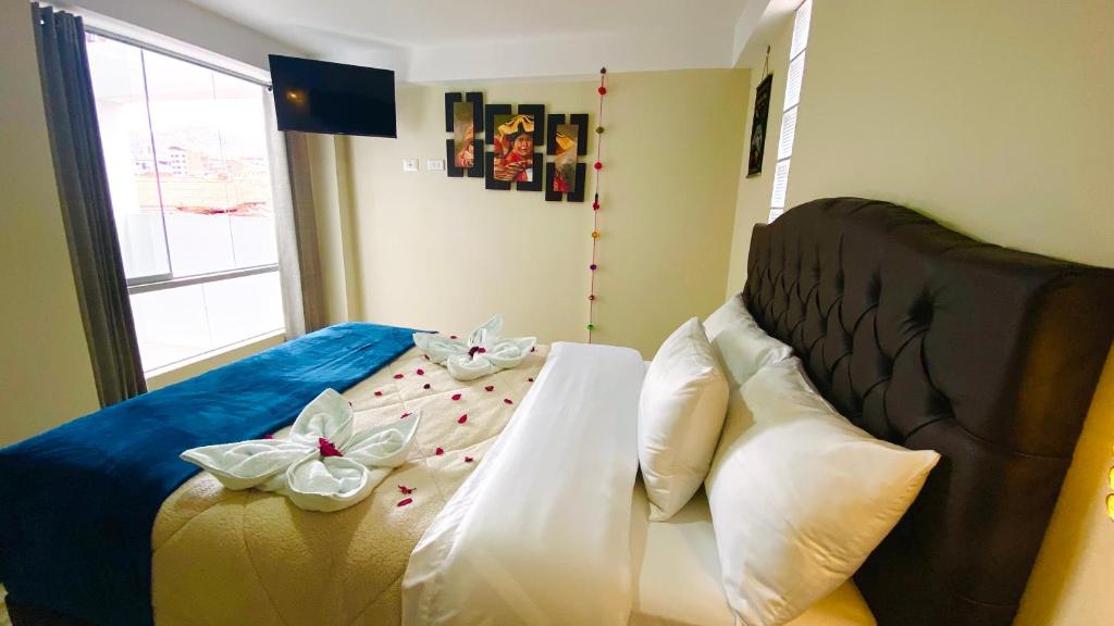 a bedroom with a bed with bows on it at Hotel Valle Andino in Cusco