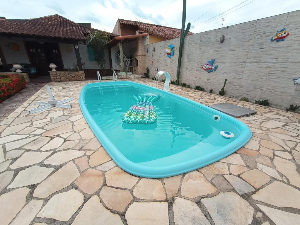 a pool with a pineapple in the middle of a yard at Casa da Lua in São Pedro da Aldeia