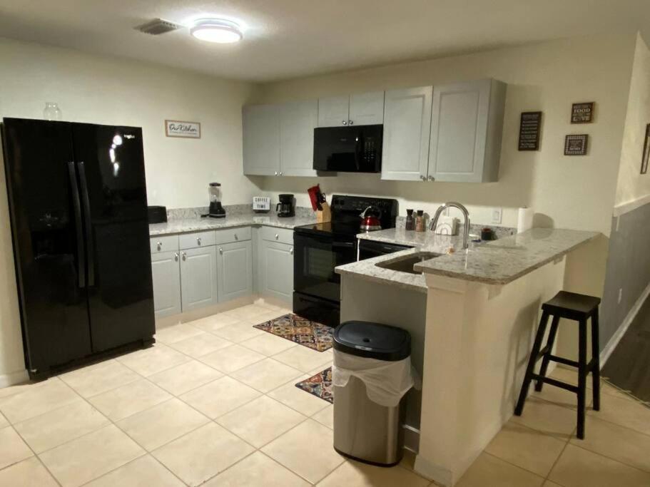una cucina con un lavello e un frigorifero nero di Disney Kissimmee Condo a Kissimmee