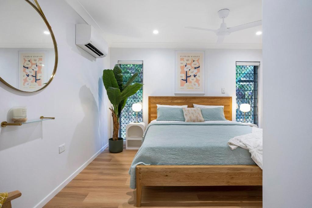 Schlafzimmer mit einem Bett und einem Spiegel in der Unterkunft Deco View Family Oasis in Cairns in East Trinity