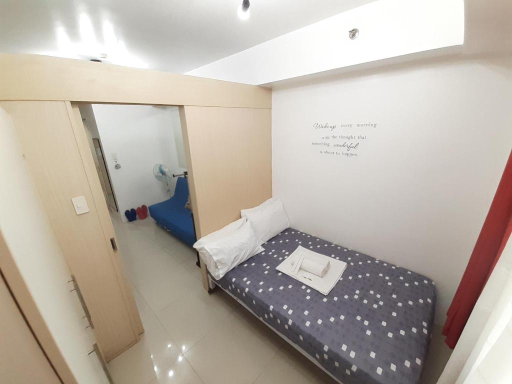 Cette petite chambre comprend un lit et un miroir. dans l'établissement Sea Residences by EXIN, à Manille