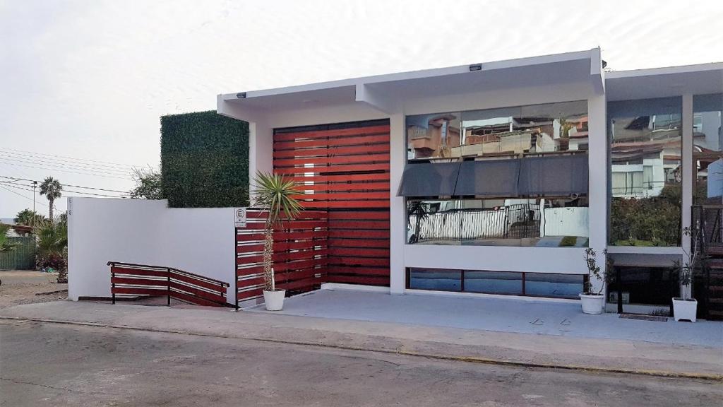 un edificio con una puerta roja al lado de un edificio en Suites & Habitaciones Acapulco La Lisera en Arica