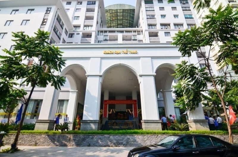 une voiture garée devant un bâtiment blanc dans l'établissement Sport Hotel HN - by BAY LUXURY, à Hanoï