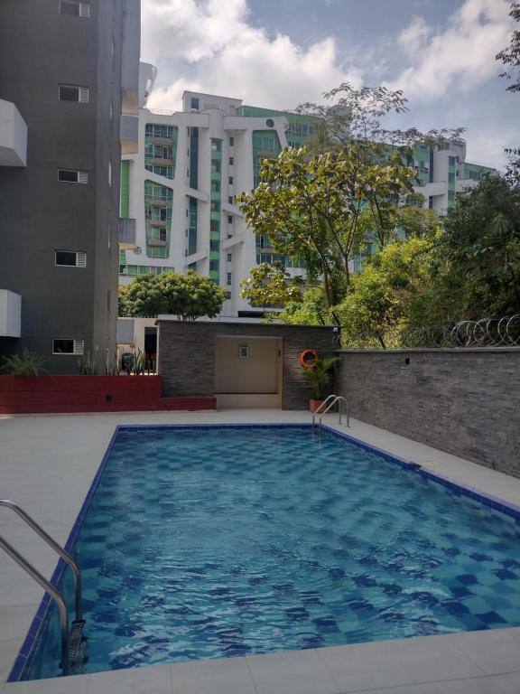 a large swimming pool with buildings in the background at Hermoso Apartamento en zona exclusiva in Armenia