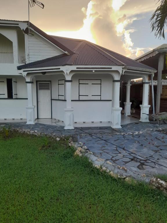 une maison blanche avec un toit marron dans l'établissement Au Moulin Paradisiaque, à Port-Louis