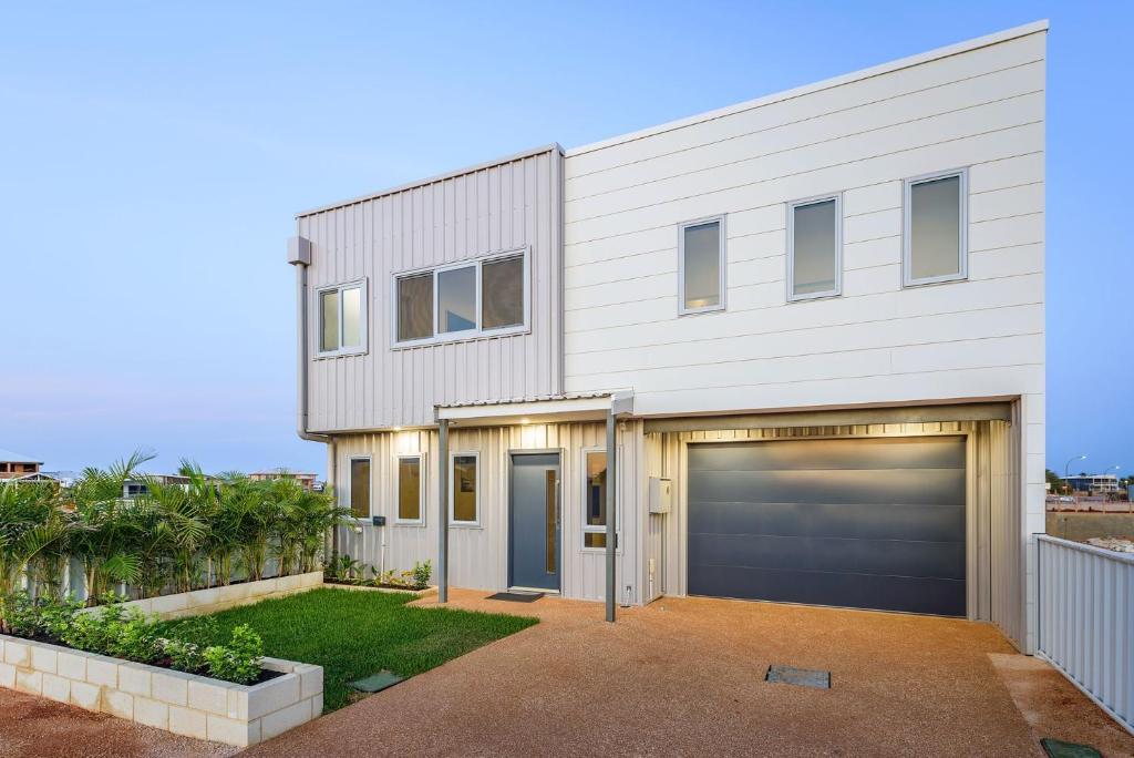 a house with two garage doors and a fence at 22 Cooyou Close in Exmouth