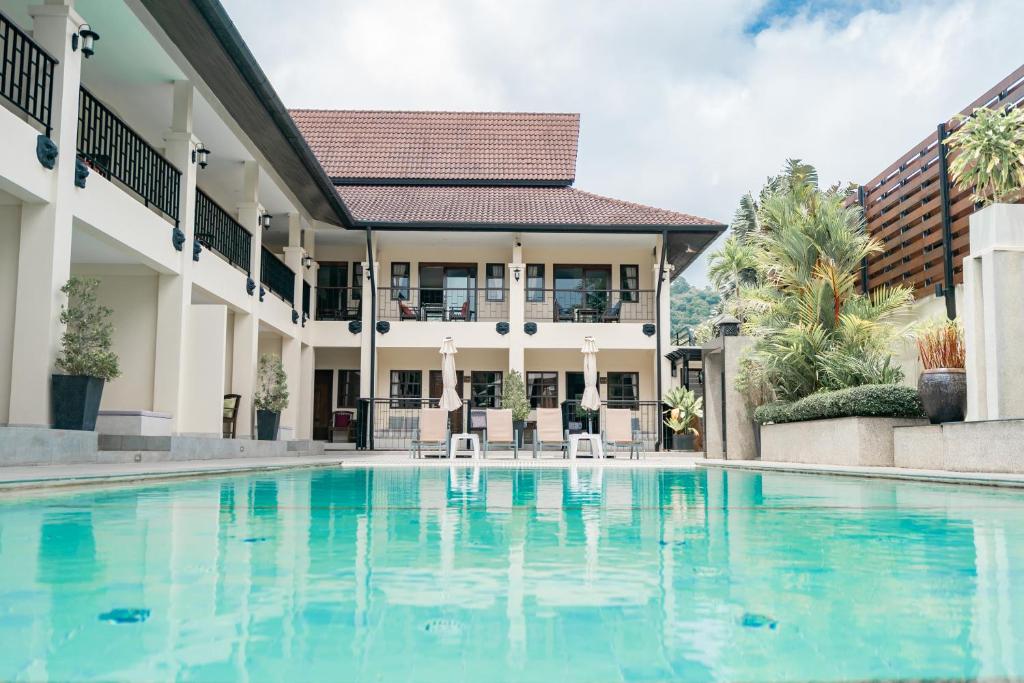 an image of a swimming pool in front of a house at Naiya Buree Boutique Resort in Rawai Beach
