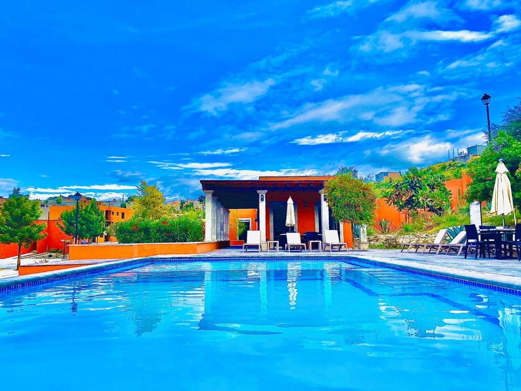 a large swimming pool with chairs and a gazebo at TriBeCa San Miguel in San Miguel de Allende