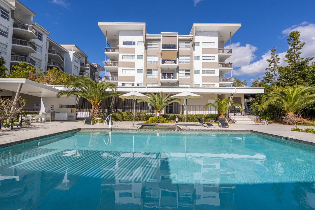 a swimming pool in front of a large apartment building at Boulevard North Lakes in North Lakes