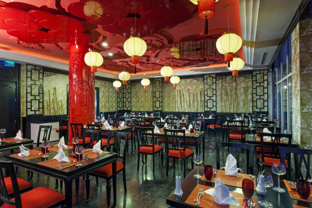 a restaurant with tables and chairs and chinese lights at Sherwood Exclusive Kemer - Kids Concept in Kemer