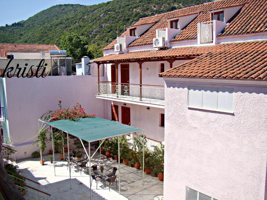 a building with a table and chairs on a patio at Kristi in Póros Kefalonias