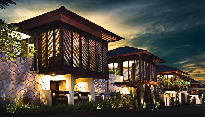 a house with a building with a sunset in the background at Puri Hiromi Boutique Residence in Sanur
