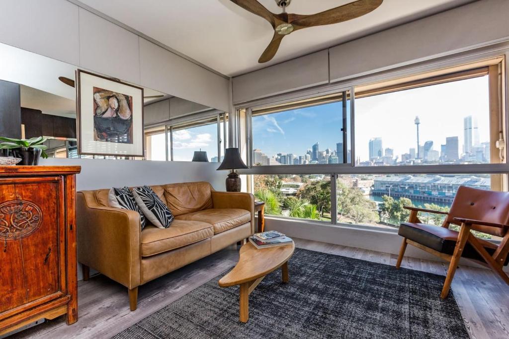 a living room with a couch and a large window at Best Sydney Views from Potts Point with Rooftop Pool in Sydney