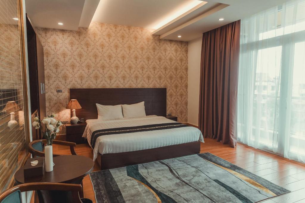 a bedroom with a bed and a table and a window at J&C HOTEL in Bắc Ninh