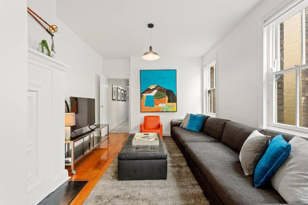 悉尼Eclectic Heritage Comfort with Terrace and Views的客厅里有一张沙发和一张桌子。