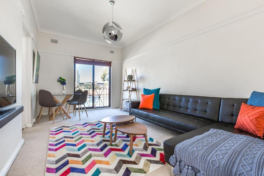 uma sala de estar com um sofá e uma mesa em Harbourfront Art Deco Hall - Sought-after in Sydney em Sydney