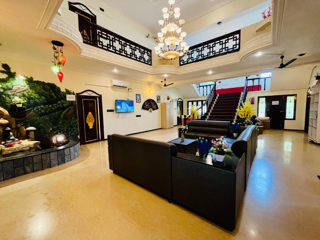 a large living room with couches and a chandelier at Bluemoon Bungalow in Pondicherry