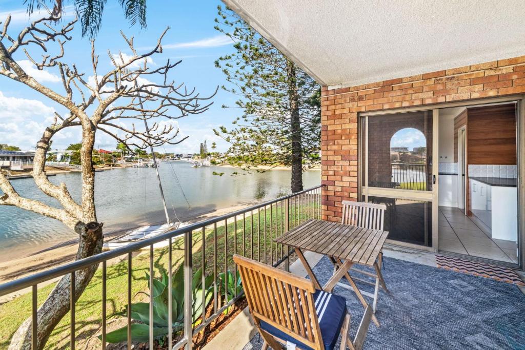 a balcony with a table and a view of the water at Anjuna, 2 bedroom apartment on canal in Mooloolaba