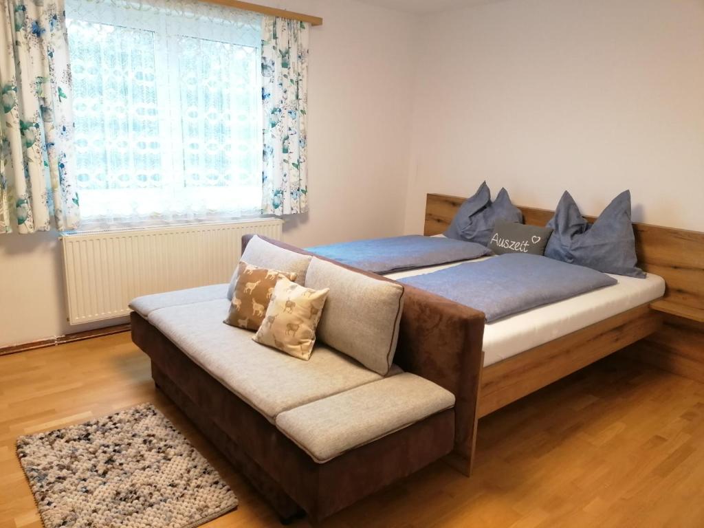 a bedroom with two beds and a couch and a window at Apartment Anna im Mostviertel in Seitenstetten Markt