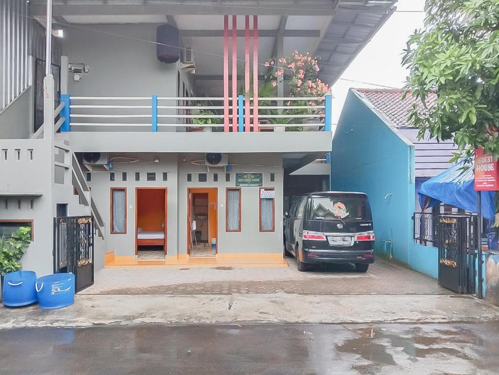 a small car parked in front of a building at RedDoorz at Rita Guesthouse Pangandaran in Pangandaran