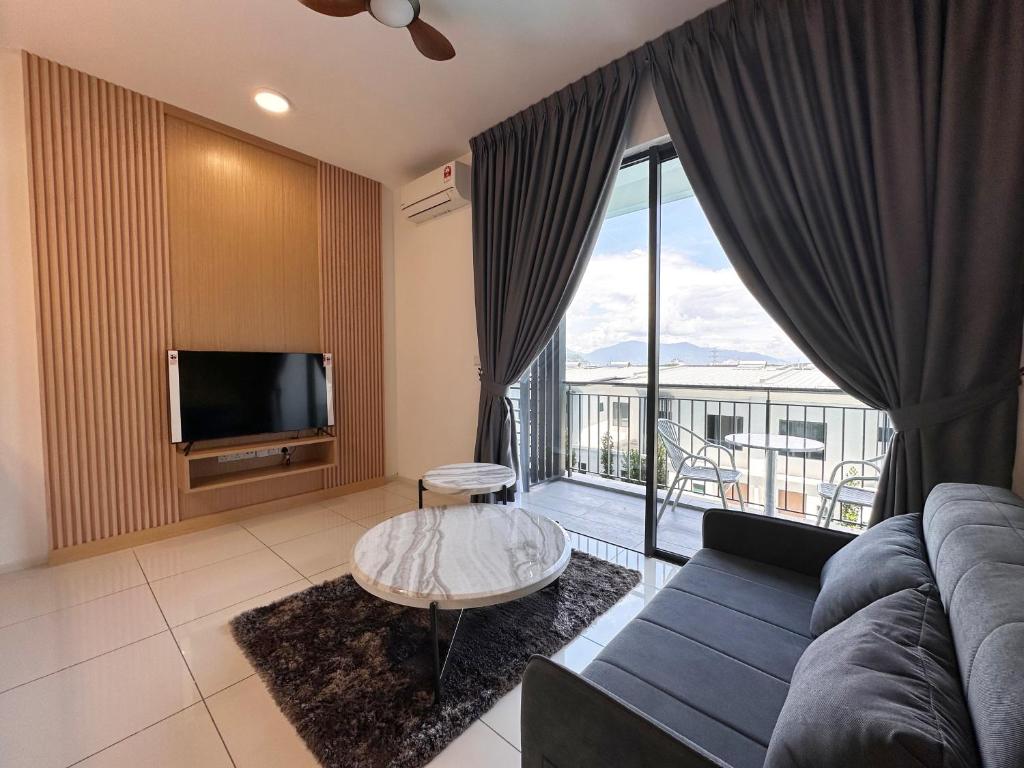 un salon avec un canapé et une télévision dans l'établissement Cozy Loft at Sunway Onsen, à Kampong Batu Lapan
