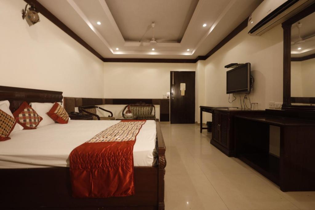 a bedroom with a bed and a flat screen tv at Hotel Clark Height @New Delhi in New Delhi