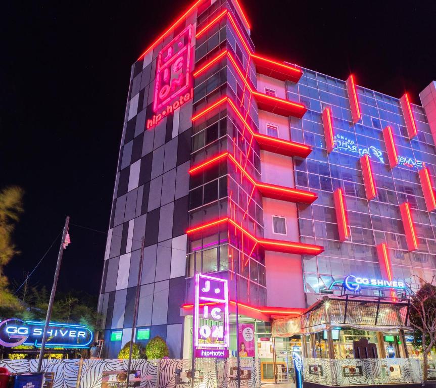 un bâtiment avec des panneaux de néon sur son côté dans l'établissement J Icon Hip Hotel, à Balikpapan