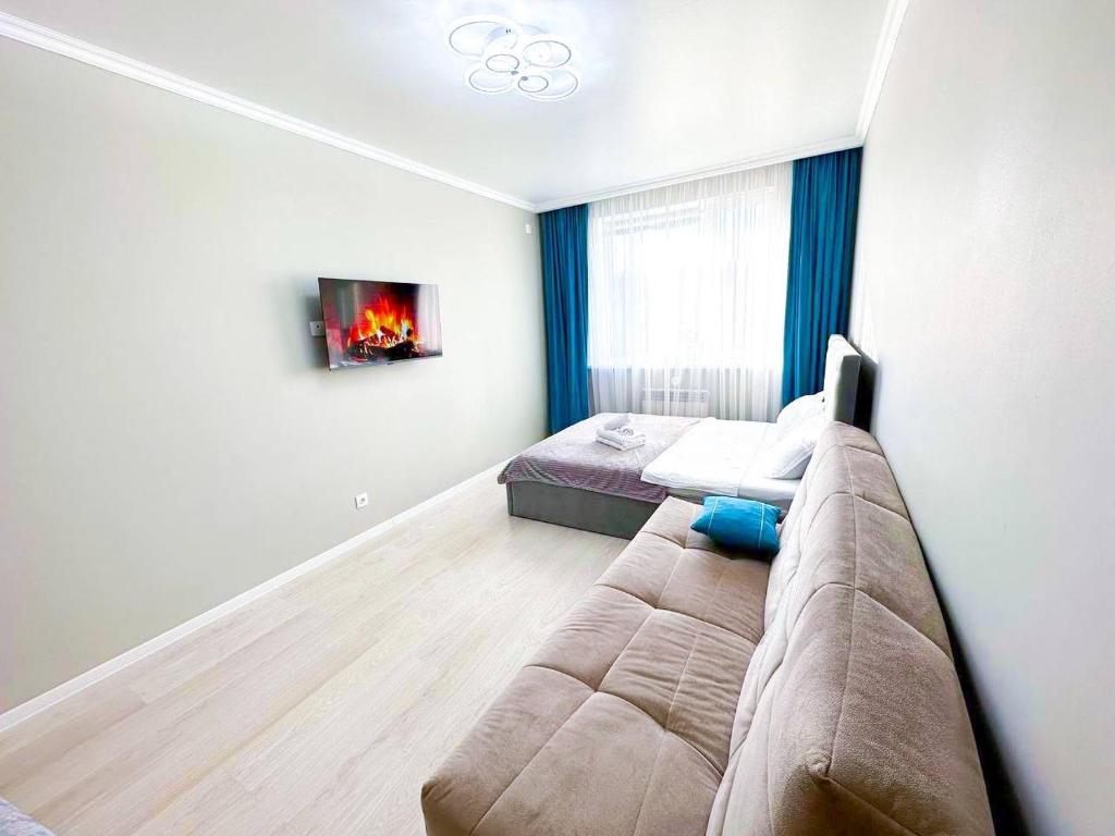 uma sala de estar com um sofá e uma cama em New 1 bedroom рядом ханшатыр em Astana